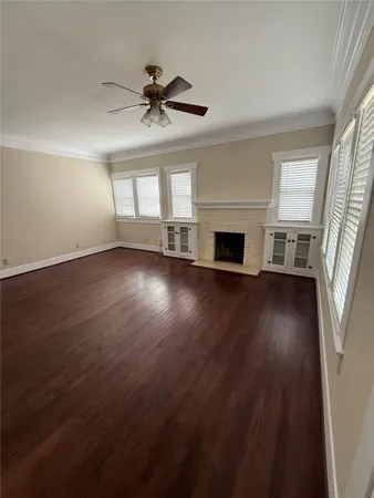 wooden floor fireplace and windows in an empty room