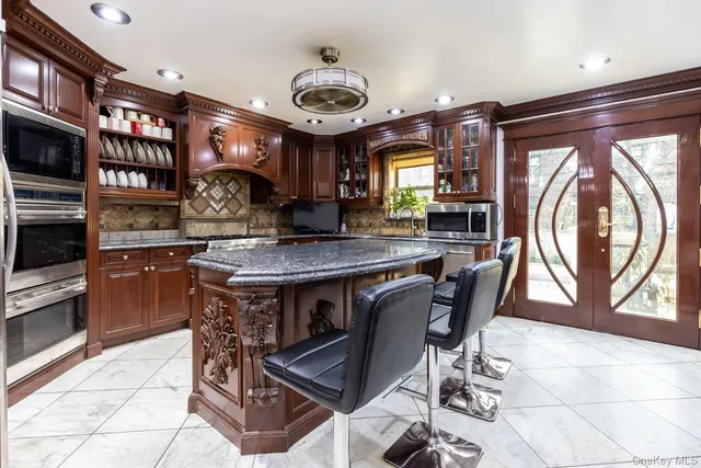 a kitchen with stainless steel appliances granite countertop a stove a sink a dining table and chairs