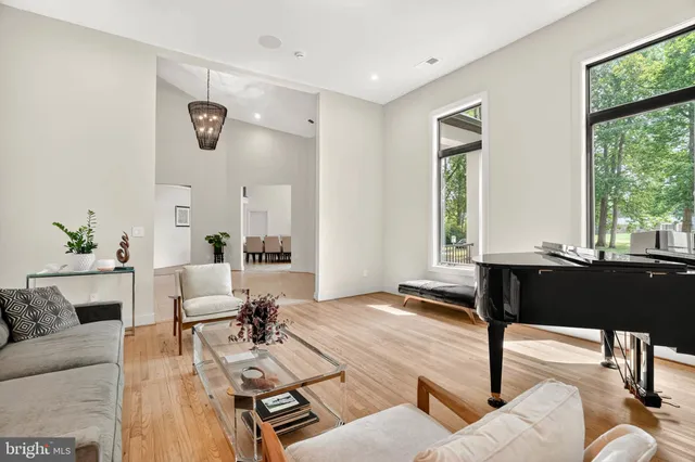 a spacious bedroom with a bed a dresser and a painting on the wall