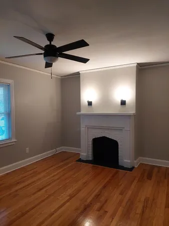 a view of empty room with wooden floor and fireplace
