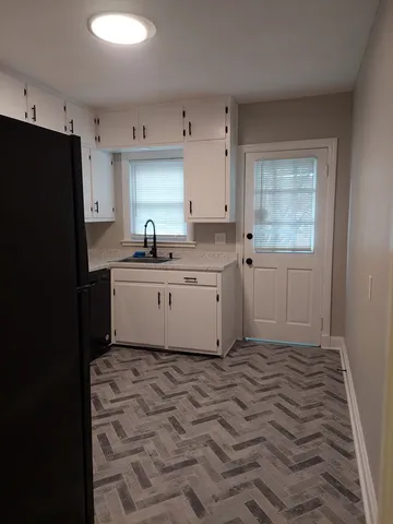 a kitchen with a sink a refrigerator and window