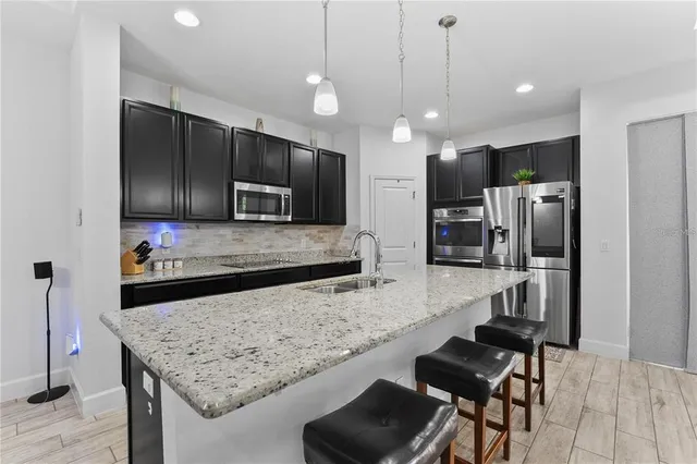 a kitchen with granite countertop stainless steel appliances window a sink and a counter top space
