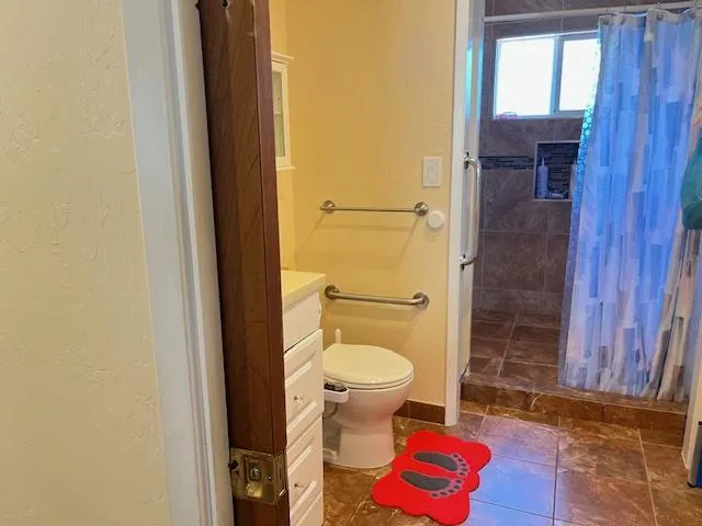 a bathroom with a toilet and a shower