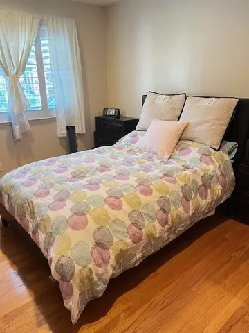 a bed sitting in a bedroom next to a window