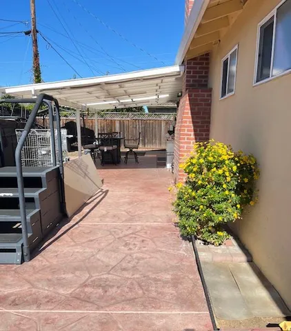 a view of a patio with table and chairs potted plants
