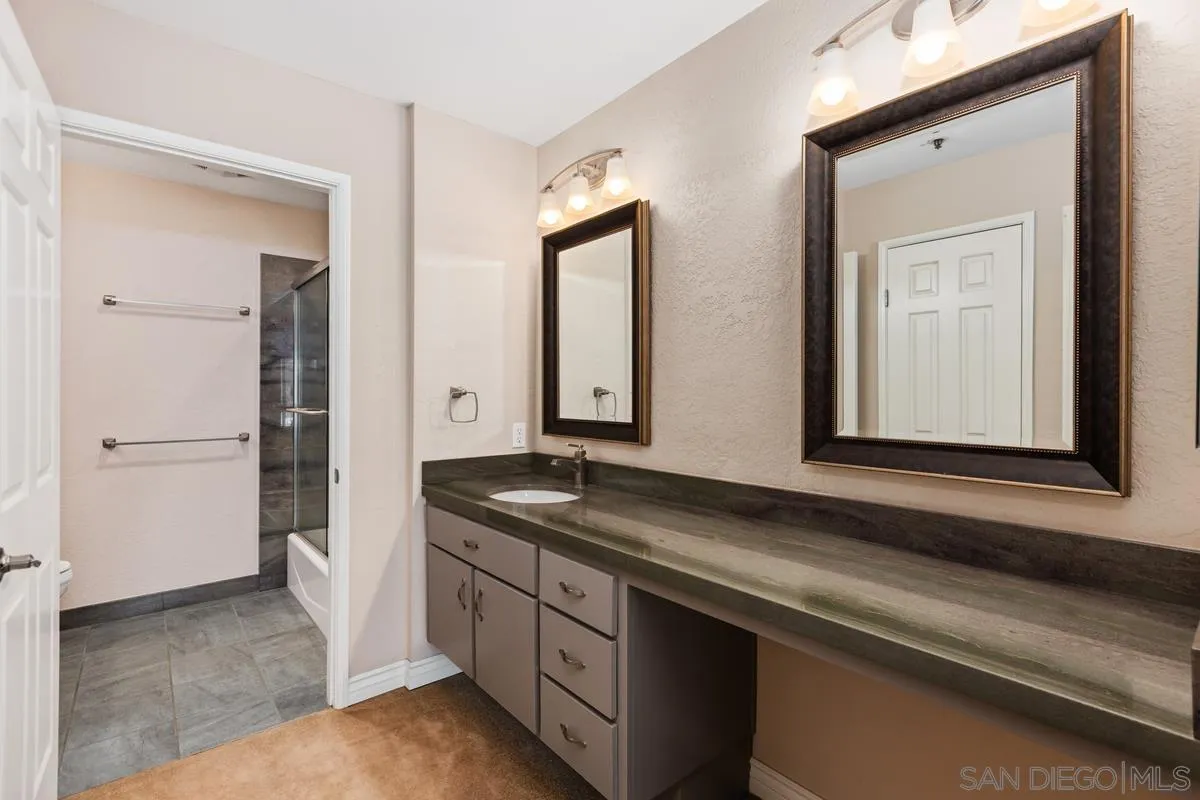 5645 Friars Road, Unit 397 San Diego, CA 92110 - Photo 7 of 22 a bathroom with a granite countertop sink and a mirror