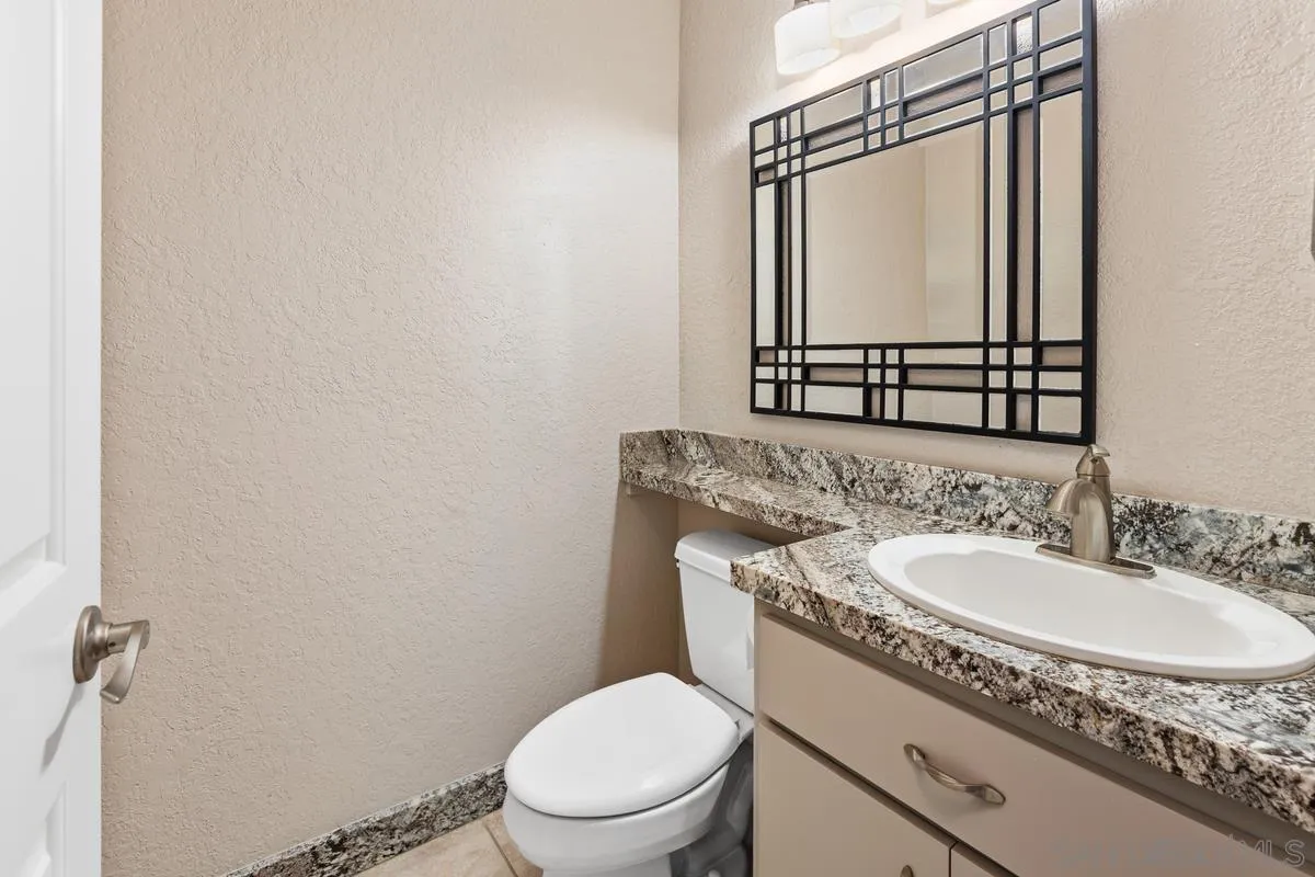 5645 Friars Road, Unit 397 San Diego, CA 92110 - Photo 9 of 22 a bathroom with a granite countertop toilet sink and mirror