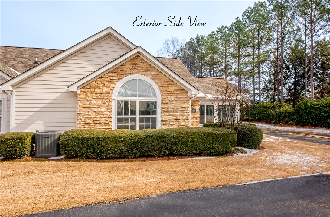 113 Life Style Lane Anderson, SC 29621 - Photo 18 of 28 This residence showcases a harmonious blend of natural stone and siding, complemented by lush, mature trees.