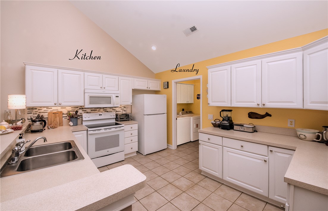 113 Life Style Lane Anderson, SC 29621 - Photo 6 of 28 Bright and functional kitchen featuring vaulted ceilings and a seamless laundry area.