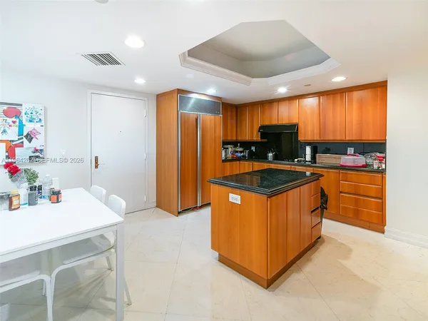 a kitchen with stainless steel appliances granite countertop a sink a stove and a refrigerator