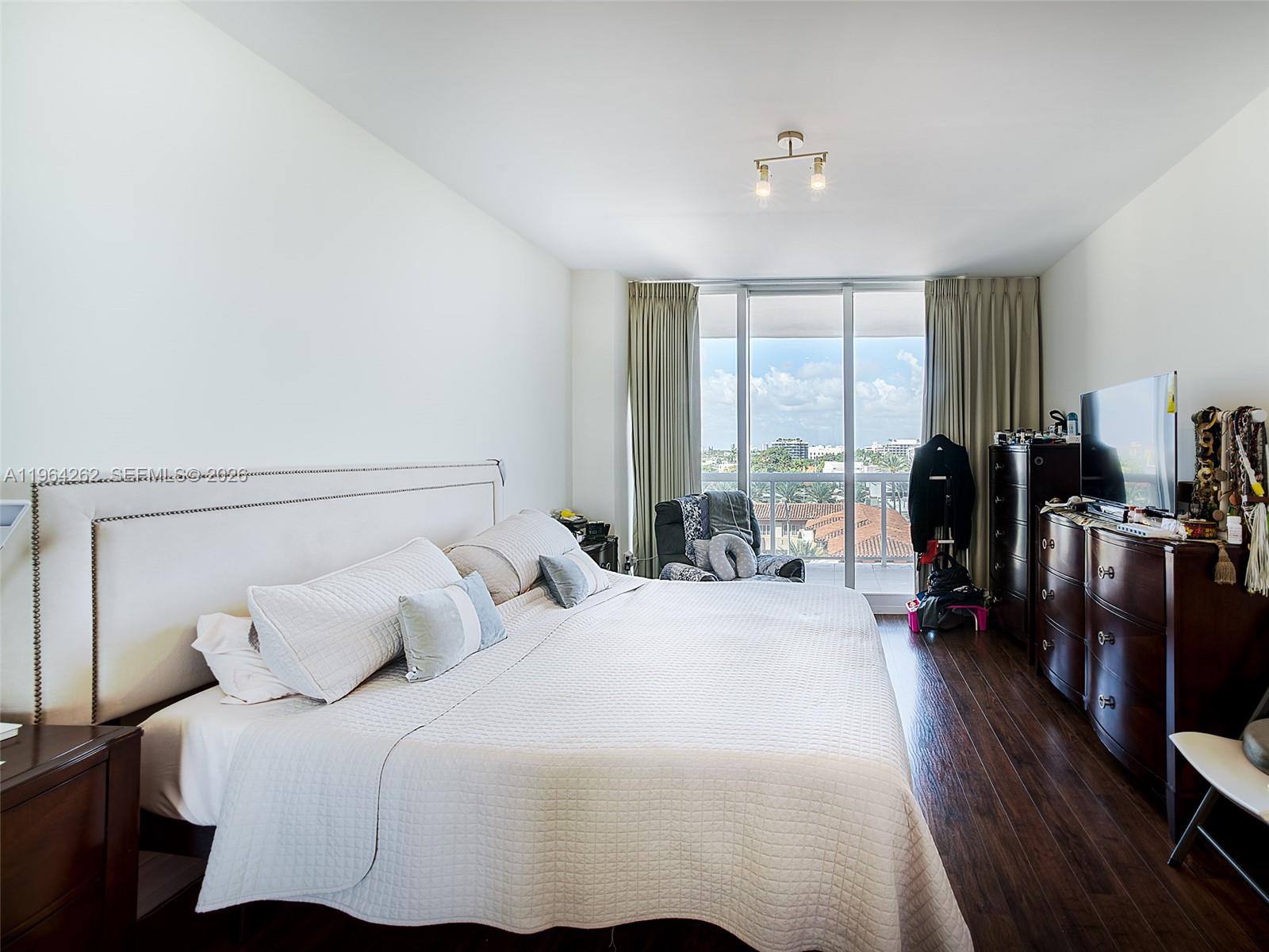 9595 Collins Avenue, Unit N5G Surfside, FL 33154 - Photo 7 of 12 a bedroom with a balcony a bed and a large window