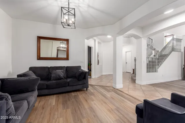 a living room with furniture a large window and a chandelier