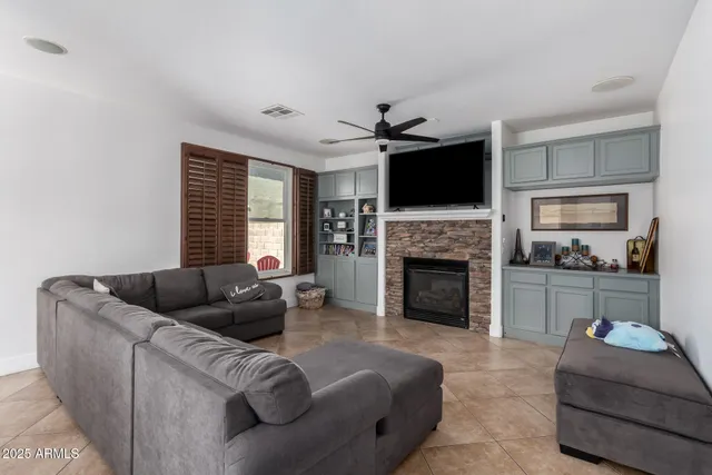 a living room with furniture a fireplace and a flat screen tv