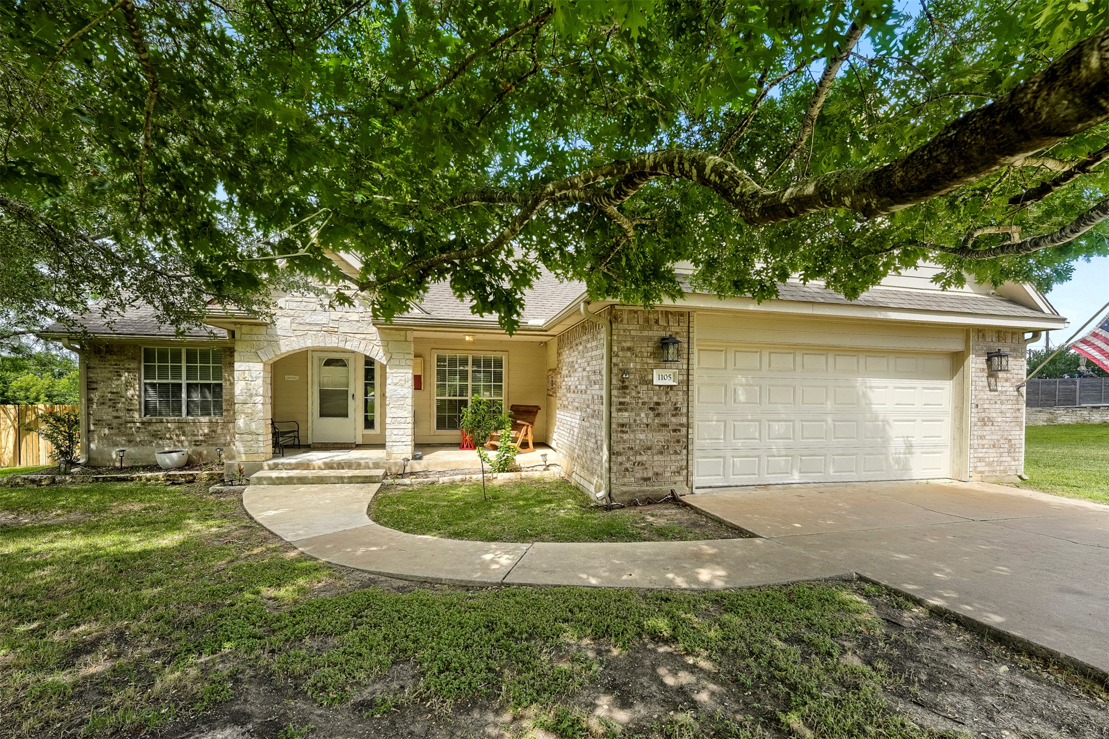 1105 2nd Street Jarrell, TX 76537 - Photo 1 of 27 A classic brick and stone facade welcomes guests with a charming arched entry and a convenient attached garage.