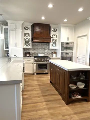 a large kitchen with stainless steel appliances granite countertop a stove a sink and a microwave