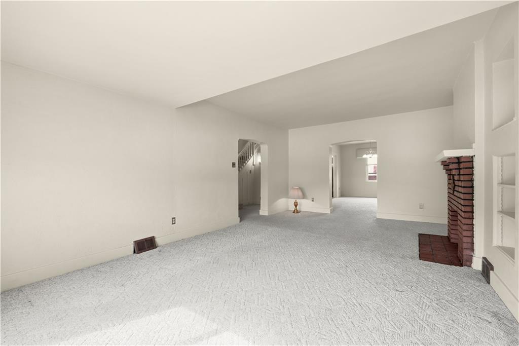7215 Whipple Street Pittsburgh, PA 15218 - Photo 11 of 46 an empty room with fireplace and stairs