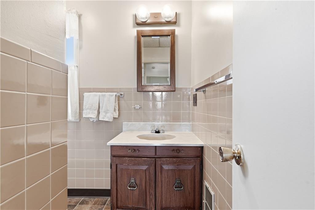 7215 Whipple Street Pittsburgh, PA 15218 - Photo 29 of 46 a bathroom with a sink a vanity and a mirror