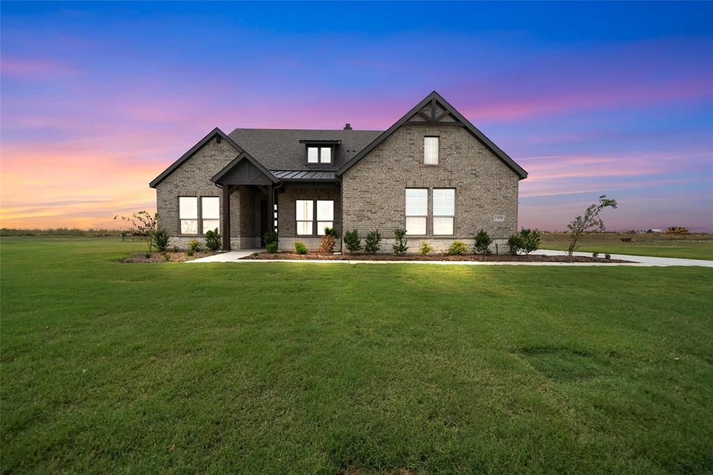 Modern farmhouse style home with brick siding, a standing seam roof, a metal roof, and a yard