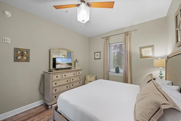 a bedroom with a bed and a flat tv screen on dresser