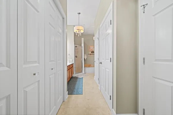 a view of a hallway with wooden floor and a bathroom