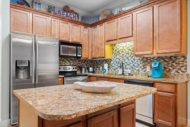a kitchen with stainless steel appliances granite countertop a sink refrigerator and microwave