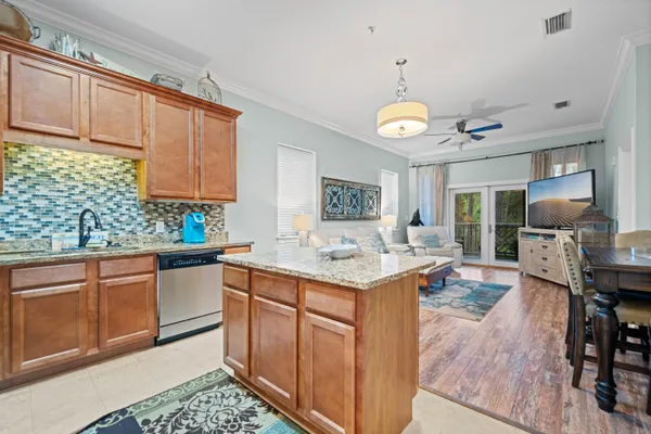 a kitchen with granite countertop cabinets a stove a sink and a wooden floors