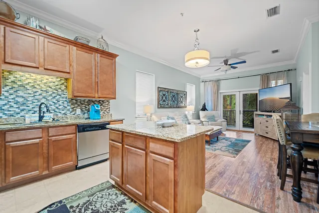 a kitchen with granite countertop cabinets a stove a sink and a wooden floors