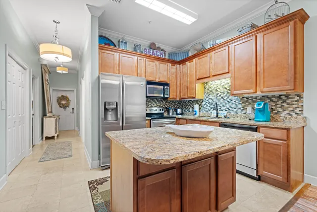 a kitchen with stainless steel appliances granite countertop a sink and a refrigerator