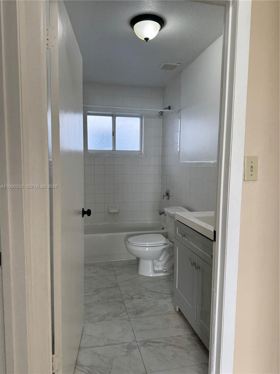 1124 Northwest 3rd Street Miami, FL 33128 - Photo 5 of 5 a bathroom with a toilet a sink and shower