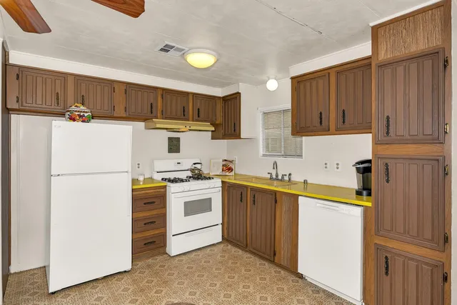 a kitchen with a sink a stove a refrigerator and cabinets
