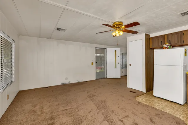 a view of a kitchen with a refrigerator and a ceiling fan