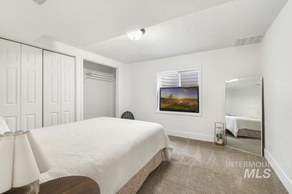 2243 4000 North Filer, ID 83328 - Photo 18 of 30 Bedroom featuring carpet flooring, two closets, and a textured ceiling