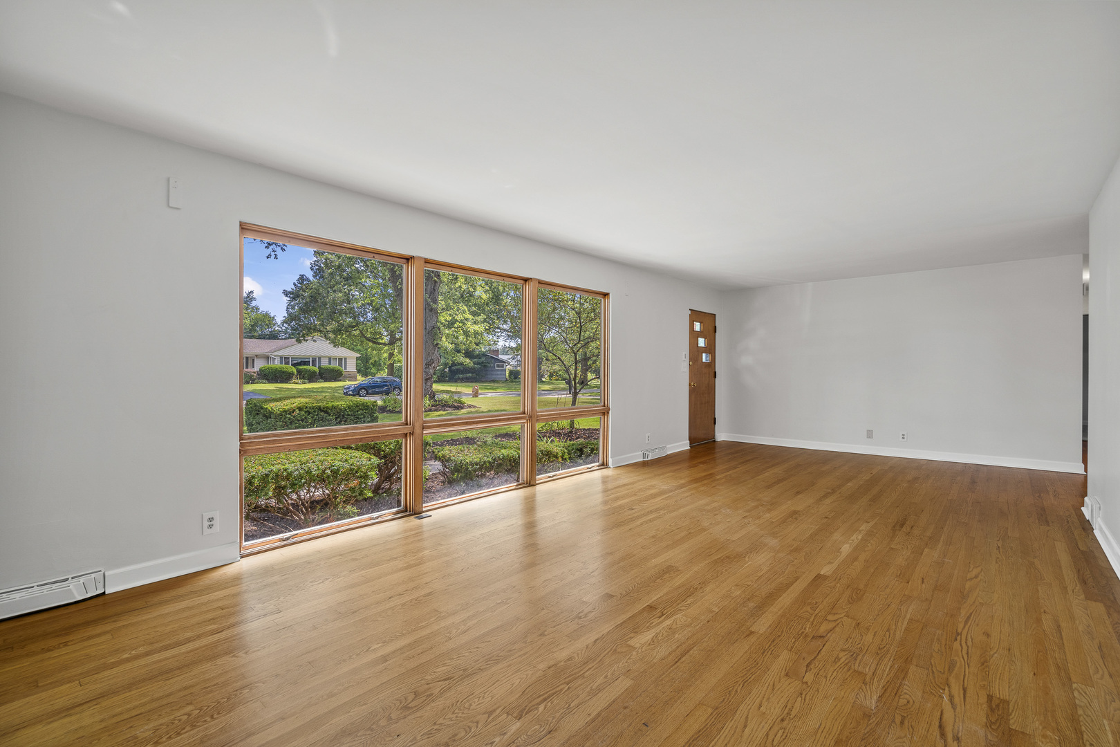 7S174 Wild Cherry Road Naperville, IL 60540 - Photo 3 of 25 a view of an empty room with wooden floor and a window