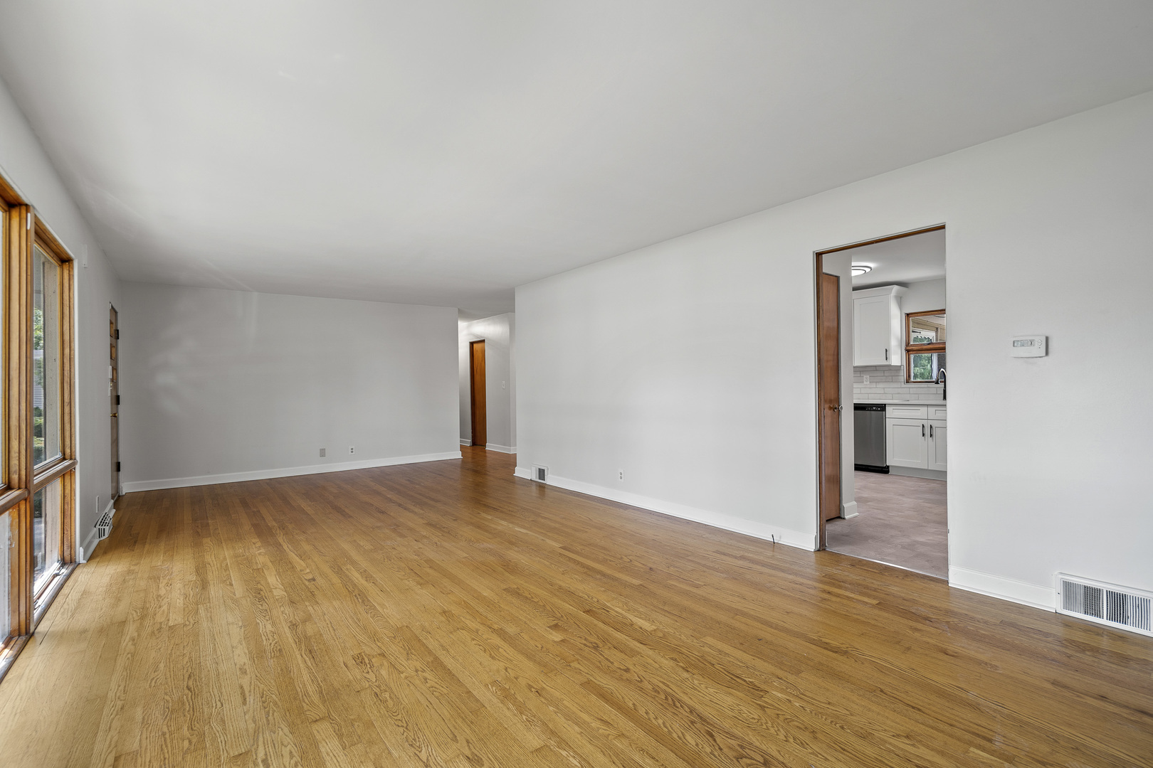 7S174 Wild Cherry Road Naperville, IL 60540 - Photo 4 of 25 a view of an empty room with wooden floor and a window