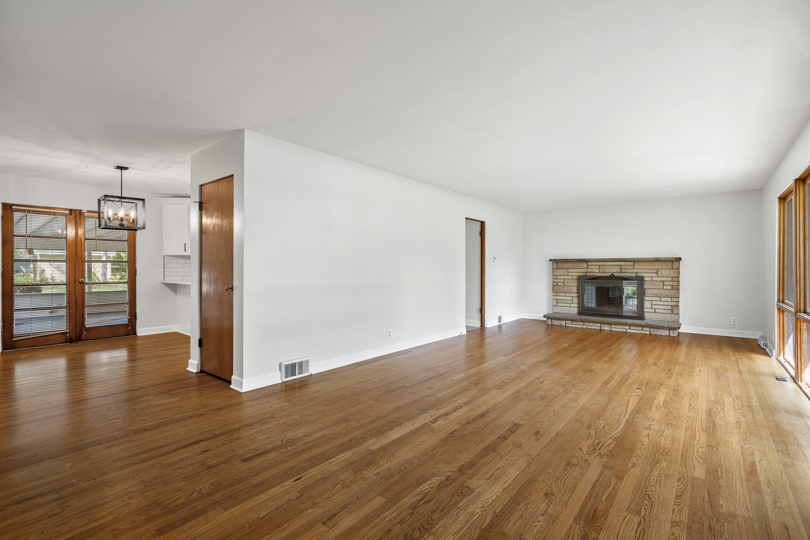 7S174 Wild Cherry Road Naperville, IL 60540 - Photo 5 of 25 an empty room with wooden floor and fireplace