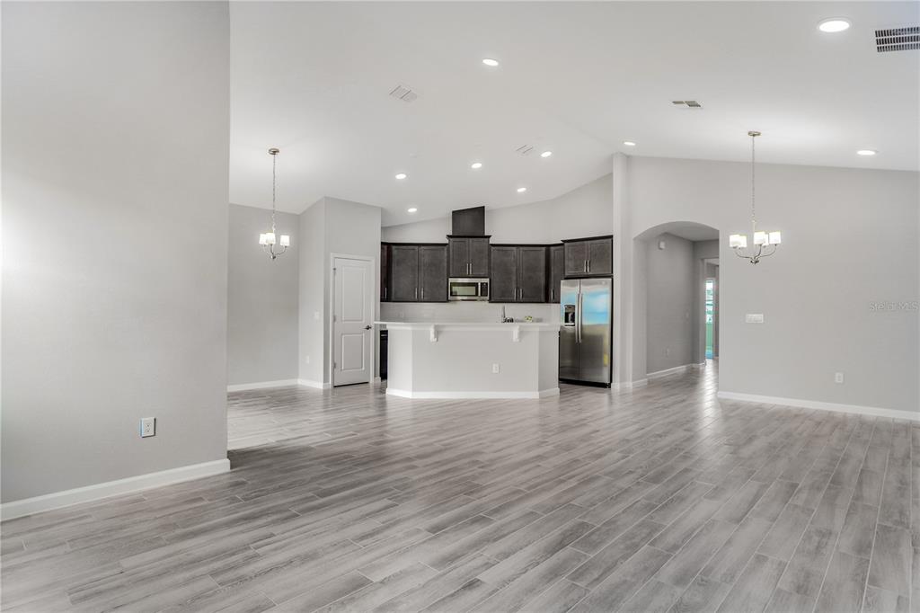 5286 Teirgarten Street St. Cloud, FL 34771 - Photo 17 of 26 a view of a kitchen with a sink and dishwasher a refrigerator with wooden floor