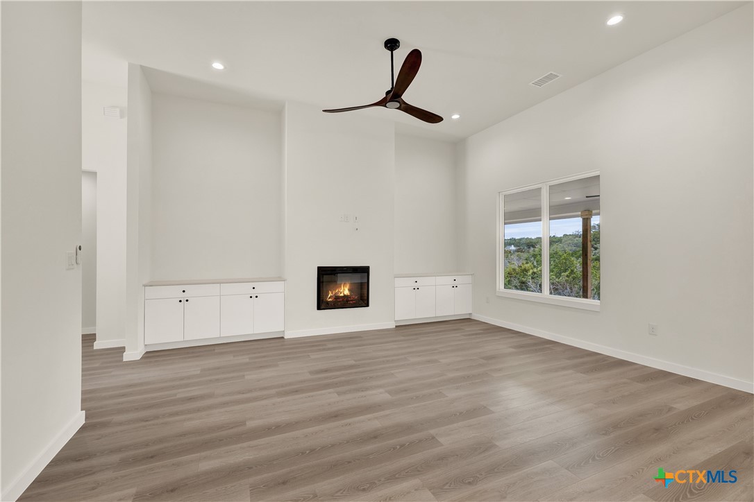 328 Compass Rose Spring Branch, TX 78070 - Photo 12 of 48 a view of a livingroom with wooden floor and a ceiling fan
