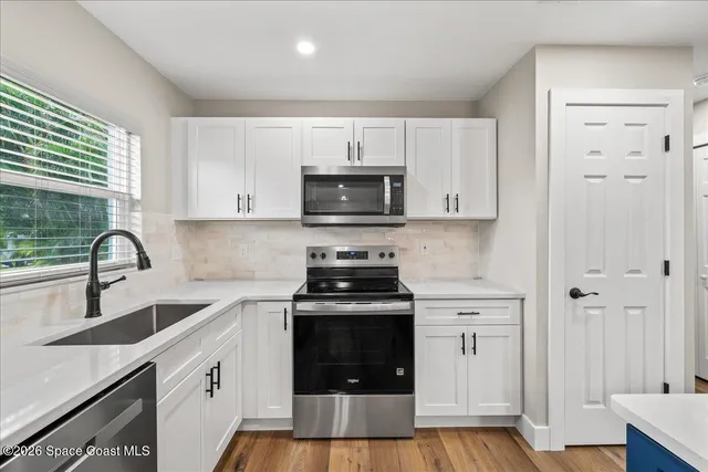 a kitchen with sink a stove and cabinets