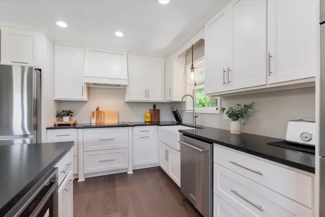 a kitchen with granite countertop white cabinets and white appliances