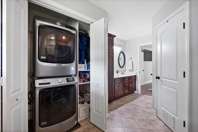 a bedroom with a large bed chandelier and a window