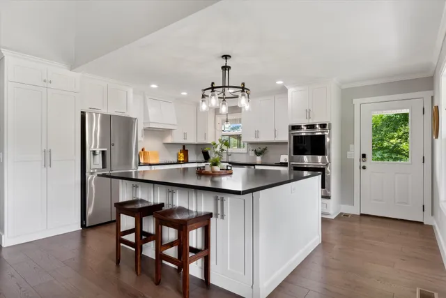 a kitchen with a sink stainless steel appliances and white cabinets