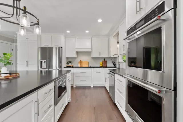 a kitchen with granite countertop white cabinets and refrigerator