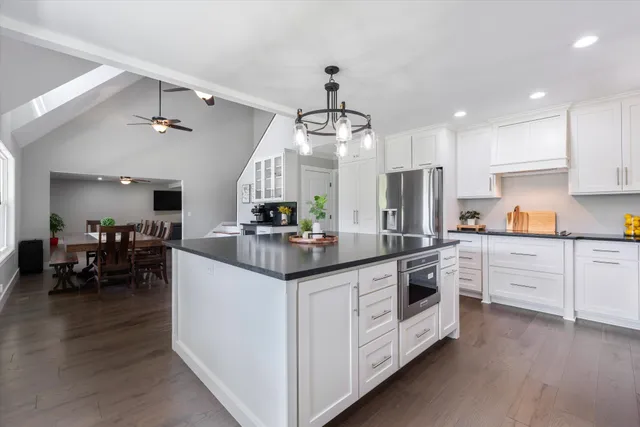 a kitchen with stainless steel appliances granite countertop a sink a stove and cabinets