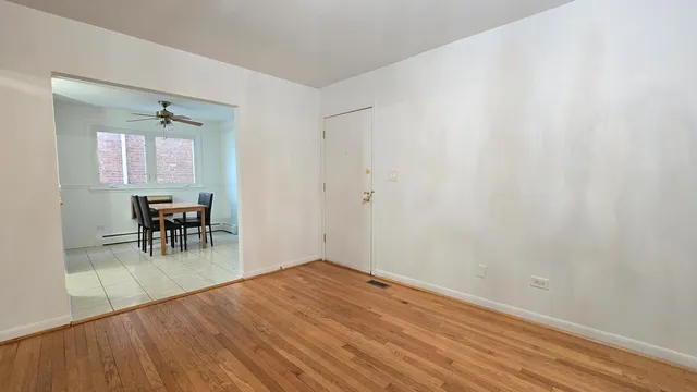 a view of a room with wooden floor table and chairs