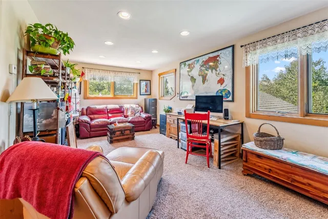 a living room with furniture a flat screen tv and a floor to ceiling window