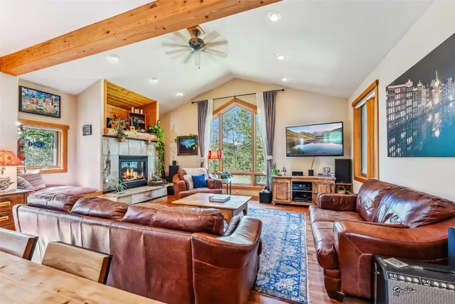a living room with fireplace furniture and a large window