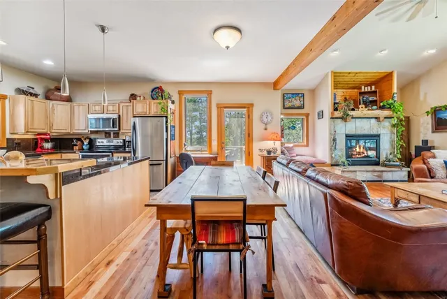 a kitchen with stainless steel appliances granite countertop a stove a sink dishwasher and a refrigerator with wooden floor