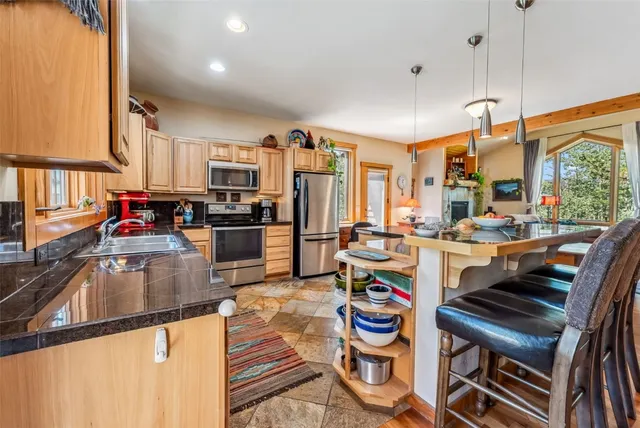 a kitchen with sink refrigerator and stove top oven
