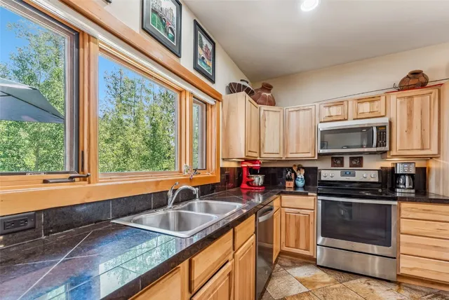 a kitchen with stainless steel appliances a sink a stove and cabinets