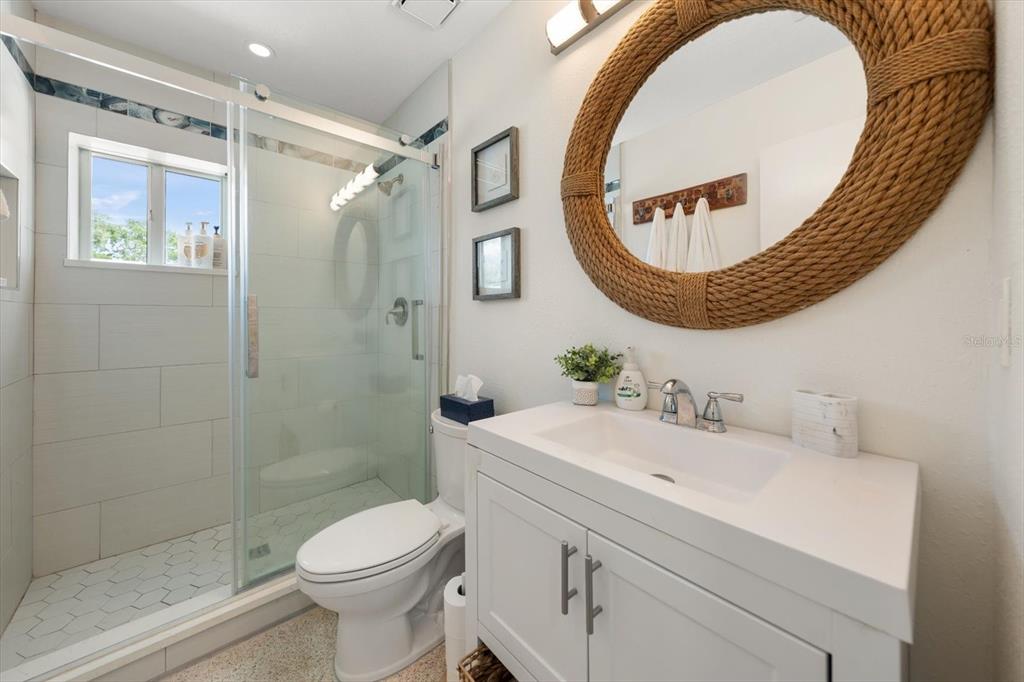 127 11th Avenue Indian Rocks Beach, FL 33785 - Photo 13 of 63 a bathroom with a sink a toilet and a mirror